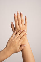 Hände mit Vanilla Fade Soft Gel Press-On Nails – zarter Nude-Farbverlauf in Mandelform von Nailish